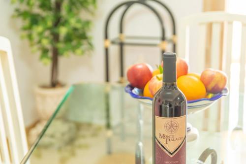 a bottle of wine sitting on a table with a bowl of fruit at Juniper -Inca- in Inca