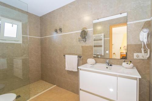 a bathroom with a sink and a shower with a mirror at Juniper -Inca- in Inca