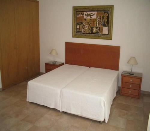 Villa Pitta في Vila Baleira: غرفة نوم بسرير ابيض كبير وموقف ليلتين