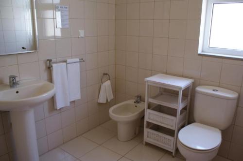 a white bathroom with a toilet and a sink at Villa Pitta in Vila Baleira