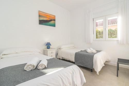 a white room with two beds and a window at Casa Blanca -Port d'Alcudia- in Port d'Alcudia