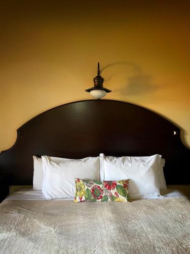 a bed with a large black headboard with white pillows at Tenondé Park Hotel in São Miguel das Missões