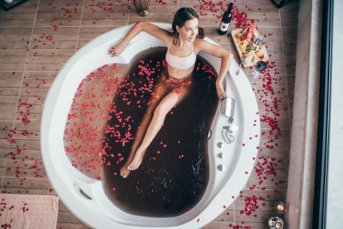 a woman is laying in a bath tub with chocolate at Gillham Vineyard Hotel in Temblos