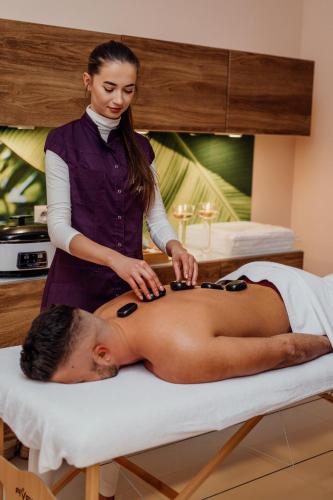 a womanolithing a man on a bed in a room at Medical Spa Kwiatowa in Łęczyca