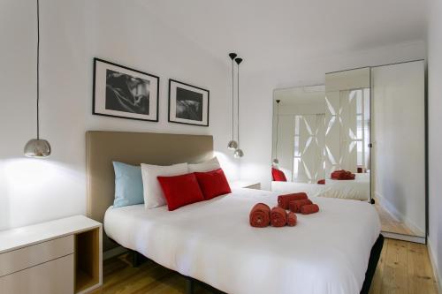 リスボンにあるBeautiful & Unique Alfamaのベッドルーム(赤い枕の大きな白いベッド付)