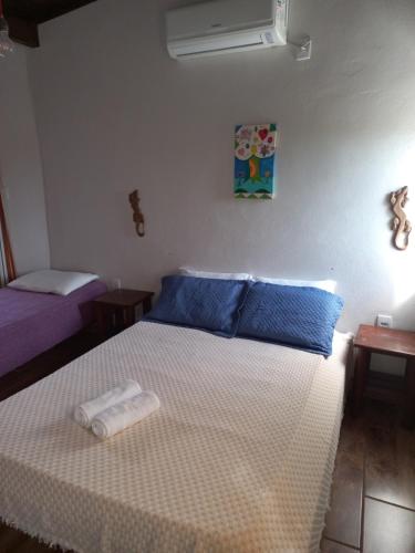 1 dormitorio con 1 cama con 2 toallas en Sol Mar, en Praia do Rosa
