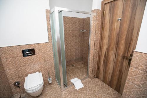 a bathroom with a toilet and a glass shower at RIVER INN RESORT AND SPA in Nabran