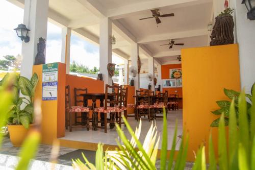 a restaurant with tables and chairs and plants at St. James Guesthouse in Roseau