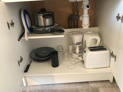 - une étagère de cuisine avec un grille-pain et des appareils électroménagers dans l'établissement Studio 32 - Résidence Beauséjour - Fibre wifi - Proche centre ville, à Troyes