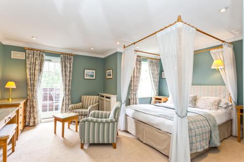 a bedroom with a canopy bed and a chair at Bridge Hotel in Buttermere