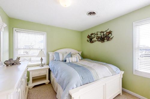 um quarto com paredes verdes, uma cama e uma janela em Sailing Away em Atlantic Beach