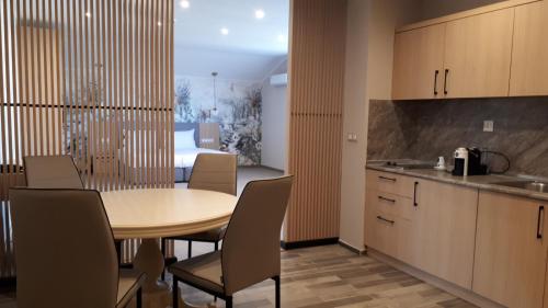 a kitchen with a table, chairs and a refrigerator at Tsarsko Selo Spa Hotel in Sofia