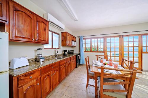 a kitchen with wooden cabinets and a table and chairs at Beach House Condos, Negril in Negril