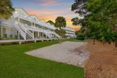 a large white building with a lawn and trees at Beach Blessings Luxe 30A Townhome 2BR 3Bath, Walk to Beach, Pool, Hot Tub in Santa Rosa Beach