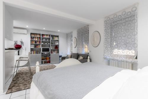 a white bedroom with a bed and a living room at Firenze Rentals - Por Santa Maria in Florence