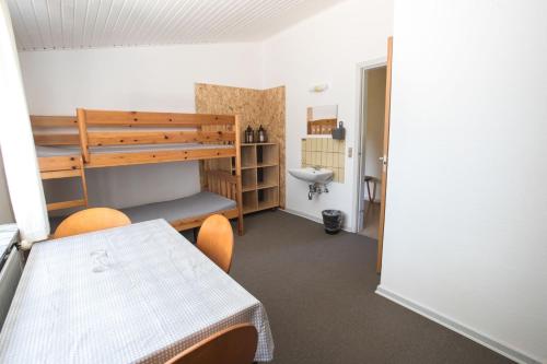 Pokój ze stołem i łóżkiem piętrowym w obiekcie Camp Nørager w mieście Avlum