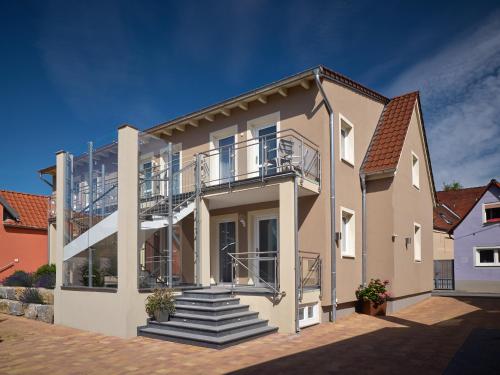 a large house with a balcony and stairs at Gästehaus Reßler in Harxheim