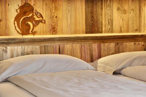 a bedroom with a wooden wall with two beds at Appartamenti Diva in Livigno