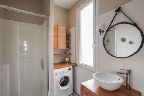 een badkamer met een wastafel en een wasmachine bij DUCHESSE - Appartement cosy en cœur de ville in Rennes