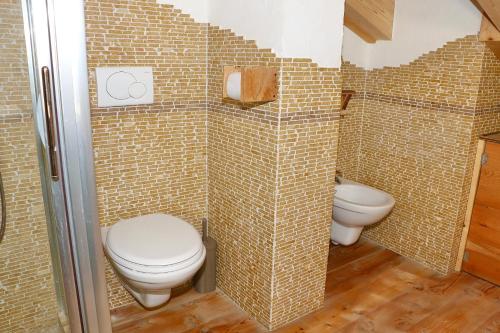 a bathroom with two toilets in a room with tiled walls at Appartamenti Diva in Livigno