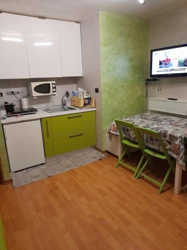 a kitchen with green and white cabinets and a table at SESTRIERE Fronte Piste in Sestriere