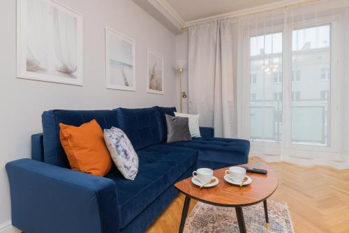 a blue couch in a living room with a table at Gdynia Śródmieście Żwirki i Wigury by Renters in Gdynia