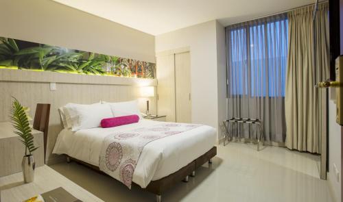 a bedroom with a large bed and a large window at Hotel Soratama in Pereira