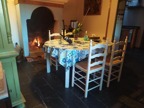 a table and chairs with a table and a fireplace at Casa Almenara in Almenara de Tormes