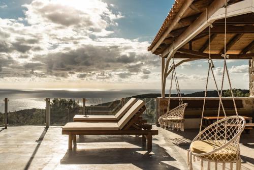 a patio with chairs and a table and a view at StoneMill Villa, a Sumptuous Escape, By ThinkVilla in Éxo Khóra