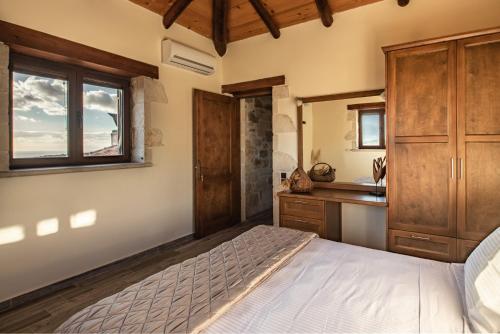 a bedroom with a bed and a sink and a mirror at StoneMill Villa, a Sumptuous Escape, By ThinkVilla in Éxo Khóra