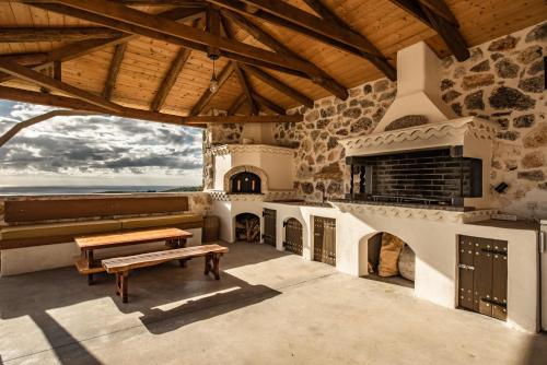 a large living room with a fireplace and a bench at StoneMill Villa, a Sumptuous Escape, By ThinkVilla in Éxo Khóra