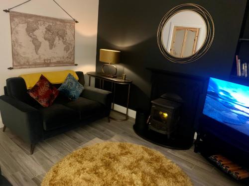 a living room with a couch and a tv and a mirror at Alta House in Westport