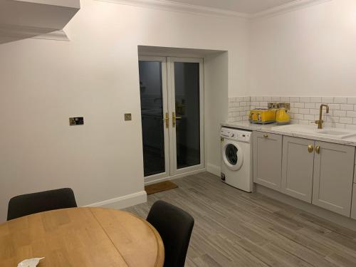 a kitchen with a table and a washing machine at Alta House in Westport
