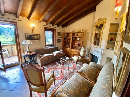 ein Wohnzimmer mit einem Sofa, Stühlen und einem Kamin in der Unterkunft Hole 1 - Cozy place on Castelgandolfo Golf Course in Castel Gandolfo