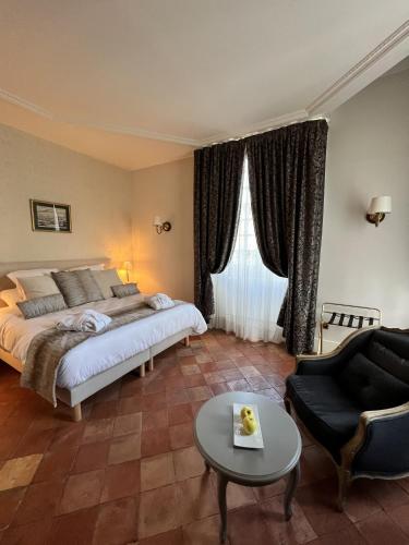 a bedroom with a bed and a couch and a table at Chambres d'hôtes Relais Mira Peis in Mirepoix
