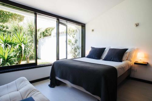 ein Schlafzimmer mit einem Bett und einem großen Fenster in der Unterkunft FOZ DO NEIVA 17 Estadia de luxo em Foz do Neiva Esposende Portugal in Moldes