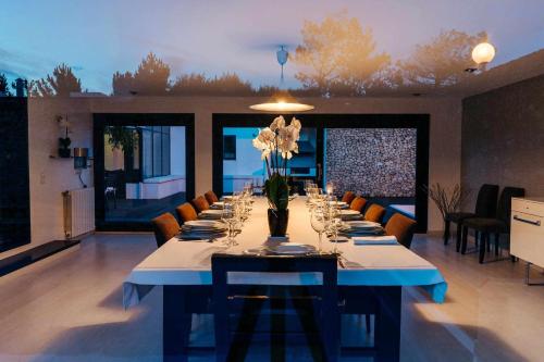 a long table with glasses and flowers in a room at FOZ DO NEIVA 17 - Estadia de luxo em Foz do Neiva, Esposende, Portugal in Moldes