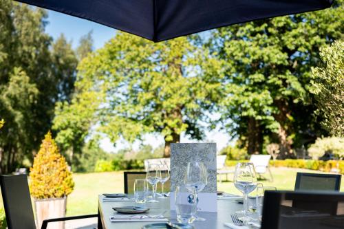 a table with wine glasses on it under an umbrella at The Spa Hotel in Royal Tunbridge Wells
