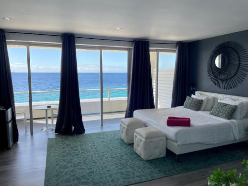 a bedroom with a bed and a view of the ocean at Saint Tropez Boutique Hotel in Willemstad