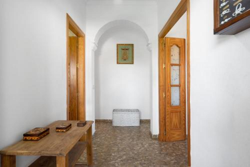 a room with a wooden table and a door at La Flor in Chiclana de la Frontera