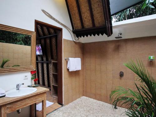 a bathroom with a sink and a shower at Mojo Resort Canggu in Canggu