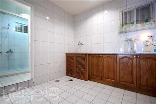 a white tiled bathroom with a shower and a sink at He Feng Homestay in Hualing
