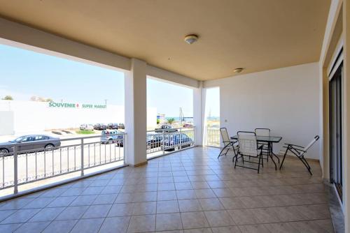 a large balcony with a table and chairs on it at Seafront Home Villa in Kato Gouves