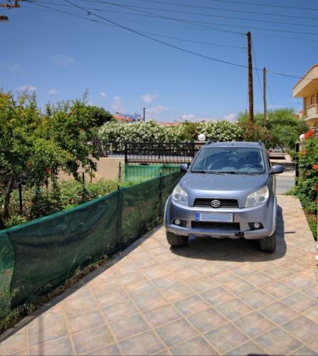 a small silver car parked in a driveway at Seafront Home Villa in Kato Gouves