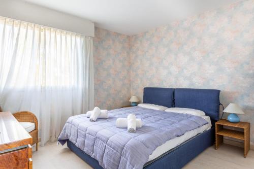 - une chambre avec un lit bleu et 2 serviettes blanches dans l'établissement Le Morane, à Antibes