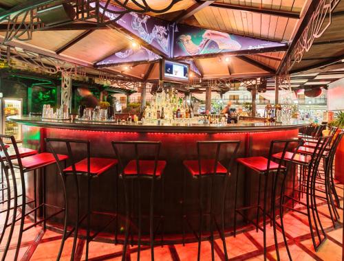 a bar with red stools in a restaurant at Art Hotel Babylon in Sunny Beach
