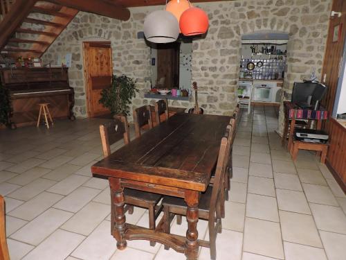 een houten tafel en stoelen in een kamer met een keuken bij La sérénité in Grazac