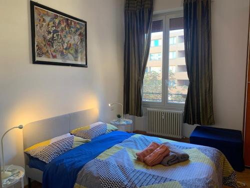 a bedroom with a blue bed and a window at Central flat beetwen centre and railway station!! in Bologna