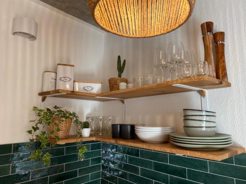 a kitchen with wooden shelves with plates and bowls at Best Butler Skyline Lodge City Apartment Netflix in Augsburg