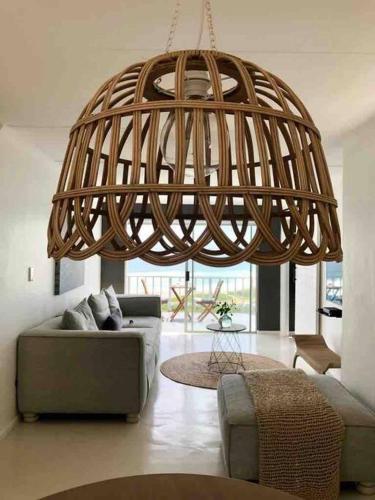 a living room with a couch and a large chandelier at TAKE TWO lovely beach apartment, Great Brak River in Groot Brak Rivier